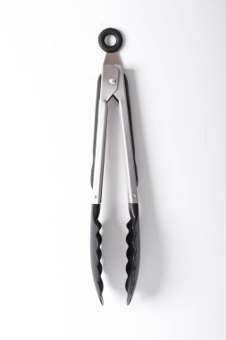 Mutfak maşası beyaz arka planda izole edilmiş. Isıya dayanıklı silikon uçlu çelik mutfak maşaları..