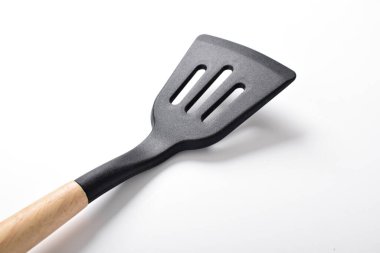İzole edilmiş beyaz arka plandaki mutfak spatulasını kapat. Tahta saplı siyah silikon spatula. Mutfak aletleri
