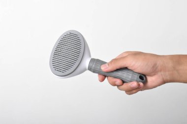 Beyaz arka planda plastik evcil hayvan fırçası var. evcil saç fırçası, evcil tarak