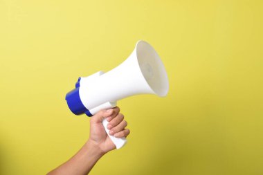 Kapalı el ele tutuşma megafonu sarı arka planda izole edilmiş. İşe alım, reklam gibi şeyler. Pankart. Boşluğu kopyala