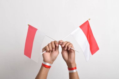 Beyaz arka planda izole edilmiş bir Endonezya bayrağını tutan insan eli. Endonezya 'nın bağımsızlık günü. Ulusal Bayram Günü ve mutlu kutlamalar.