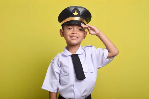 stock image Little Asian boy Airplane pilot salute isolated on yellow background. Little boy dreams of becoming an airplane pilot.