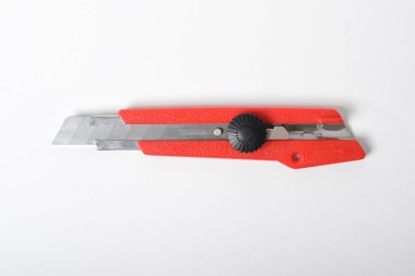 Kırmızı bıçak kesicisi beyaz arka planda izole edilmiş. Kırtasiye bıçağı.