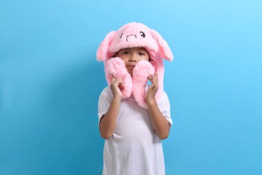 Asyalı küçük çocuk mavi arka planda sevimli bir şapka takıyor. Yakışıklı Asyalı bir çocuğun portresi.