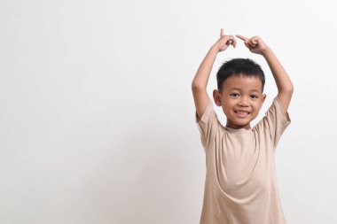 Asyalı bir çocuğun beyaz arka planda mutlu bir şekilde gülümsemesi. Asyalı bir çocuğun portresi