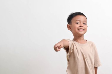 Asyalı bir çocuğun beyaz arka planda öne doğru poz vermesi. Asyalı bir çocuğun portresi