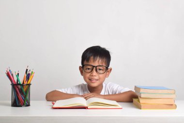 Beyaz bir arka planda özenle izole edilmiş Asyalı bir çocuğun portresi. Kameraya bakıyorum.