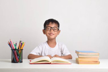 Beyaz bir arka planda özenle izole edilmiş Asyalı bir çocuğun portresi. Kameraya bakıyorum.