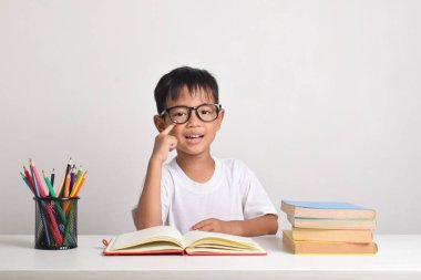 Zeki bir Asyalı çocuğun portresi, beyaz arka planda izole bir şekilde çalışıyor.