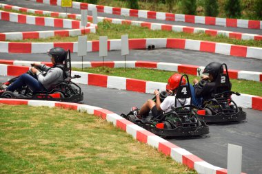 Malang, Endonezya - 20 Ekim 2024: Go kart ile yarış pistinde yarışan genç adam