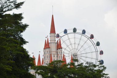 Beautiful view of Santerra De Laponte. Ferris wheel and replica of Disney Castle. Tourist destination with flower garden concept with interesting photo spots clipart