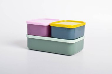 Beyaz arka planda izole edilmiş üç renkli beslenme çantası. Plastik yiyecek konteynerleri