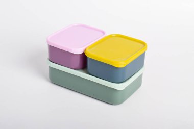 Beyaz arka planda izole edilmiş üç renkli beslenme çantası. Plastik yiyecek konteynerleri