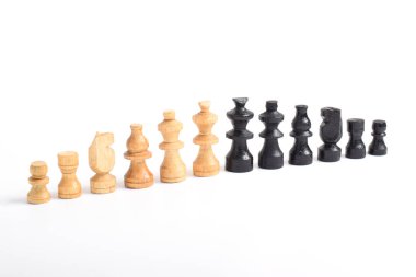 Tam takım siyah ve kahverengi tahta satranç taşları beyaz arka planda izole edilmiş.