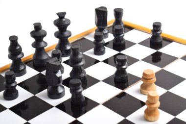 Beyaz arka planda izole edilmiş satranç tahtasındaki siyah satranç taşlarına karşı