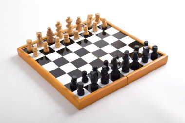 Satranç taşlarıyla tahta satranç tahtası beyaz arka planda izole edilmiş oyun için hazır.