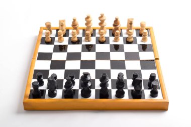 Satranç taşlarıyla tahta satranç tahtası beyaz arka planda izole edilmiş oyun için hazır.