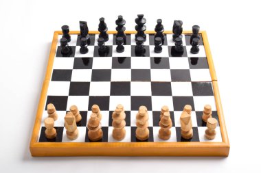 Satranç taşlarıyla tahta satranç tahtası beyaz arka planda izole edilmiş oyun için hazır.