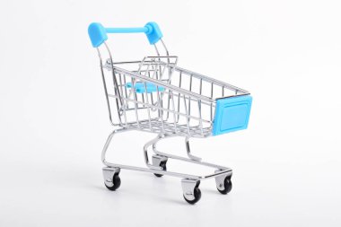 Beyaz arka planda mavi alışveriş arabasının mini modeli. Alışveriş arabası boş.