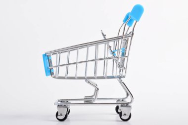 Beyaz arka planda mavi alışveriş arabasının mini modeli. Alışveriş arabası boş.