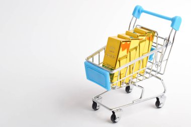 Alışveriş arabasındaki altın külçeler. Finansal konsept, ticaret, yüksek talep alımları
