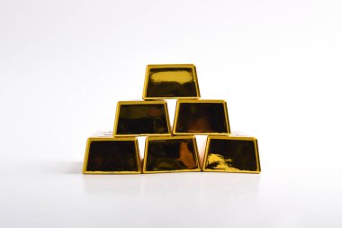 Beyaz arkaplanda izole edilmiş parlak altın külçeleri yığını