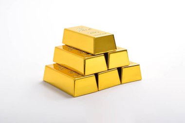 Beyaz arkaplanda izole edilmiş parlak altın külçeleri yığını