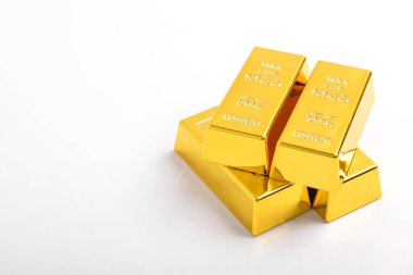 Beyaz arkaplanda izole edilmiş parlak altın külçeleri yığını