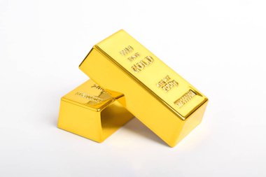 Beyaz arkaplanda izole edilmiş parlak altın külçeleri yığını