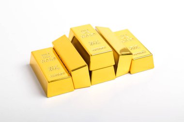 Beyaz arkaplanda izole edilmiş parlak altın külçeleri yığını