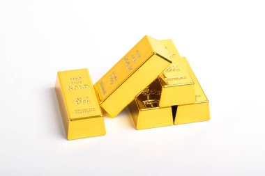 Beyaz arkaplanda izole edilmiş parlak altın külçeleri yığını