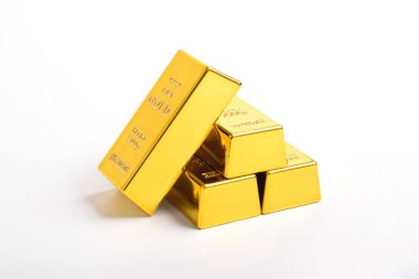 Beyaz arkaplanda izole edilmiş parlak altın külçeleri yığını