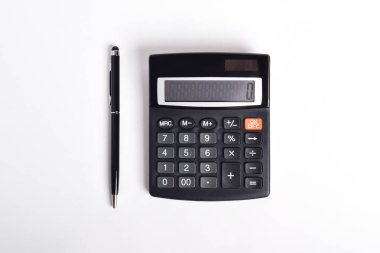 Beyaz arkaplanda izole edilmiş kalem ile siyah hesap makinesi. Mali faaliyet, muhasebe, vergi hesaplama veya tasarruf ve yatırım