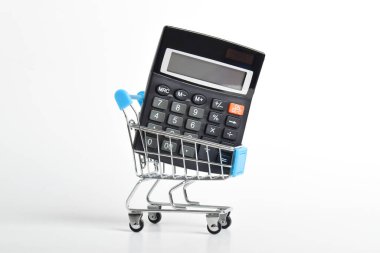 Hesap makinesi ve alışveriş arabası beyaz arka planda izole edilmiş. Alışveriş ve market alışverişi kavramı