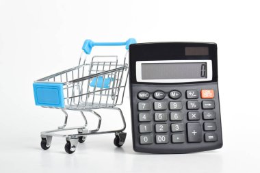 Hesap makinesi ve alışveriş arabası beyaz arka planda izole edilmiş. Alışveriş ve market alışverişi kavramı
