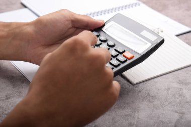 Hesap makineli bir iş adamı. Ev ekonomisi, yazma notları, masa hesapları, bütçe yönetimi hesapları. Mali işler, bütçe ve vergi hesapları, aylık harcamalar