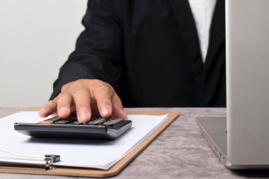 Ofis işindeki mali raporları hesaplamak için hesap makinesi kullanan bir muhasebeci. Muhasebe finans kavramı