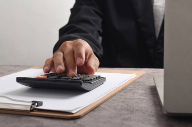 Ofis işindeki mali raporları hesaplamak için hesap makinesi kullanan bir muhasebeci. Muhasebe finans kavramı