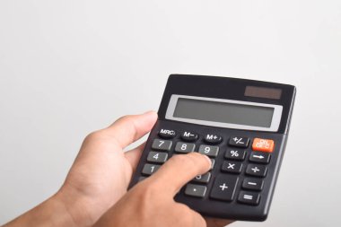 Beyaz arkaplanda izole edilmiş bir hesap makinesi kullanarak ve tutarak