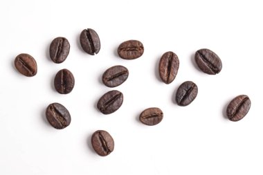 Birçok kavrulmuş kahve çekirdeği beyaz arka planda izole, üst manzara