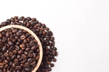 Beyaz arka planda izole edilmiş ahşap kasede kavrulmuş kahve çekirdeği. Üst Manzara. Düz yatıyordu. Metin için boşluk