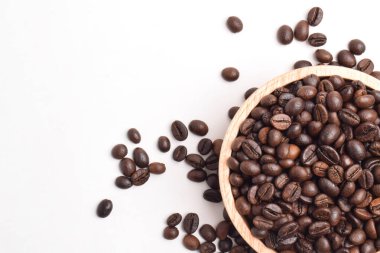 Beyaz arka planda izole edilmiş ahşap kasede kavrulmuş kahve çekirdeği. Üst Manzara. Düz yatıyordu. Metin için boşluk