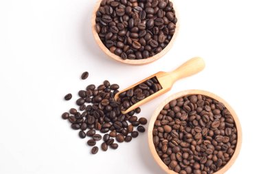 Ahşap kase beyaz arka plan üzerinde izole kavrulmuş kahve çekirdekleri