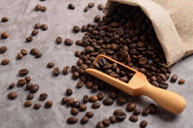 Kahverengi kahve çekirdekli çuval koyu çimento üzerine izole edilmiş. Çuval bezi. Tahıllı kepçe.