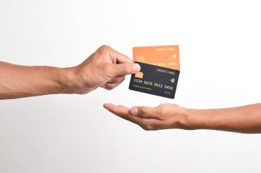 İki kredi kartı ve diğer el beyaz arka planda izole edilmiş..