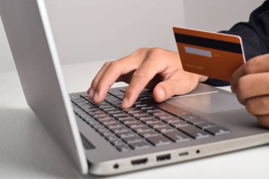 El ele tutuşma ve dizüstü bilgisayar kullanma. İş adamı ya da girişimci evde çalışıyor. Çevrimiçi alışveriş, e-ticaret, internet bankacılığı, ödeme, harcama, ev konseptinden çalışma.