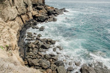 Okyanus dalgaları ve kayalık kayalıklar güzel bir sahilde