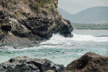 Okyanus dalgaları ve kayalık kayalıklar güzel bir sahilde