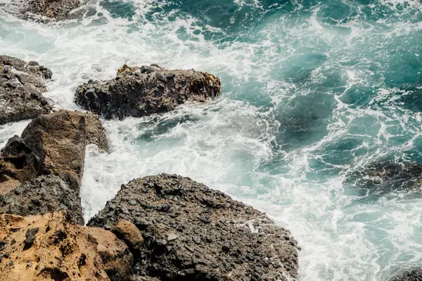 Okyanus dalgaları ve kayalık kayalıklar güzel bir sahilde