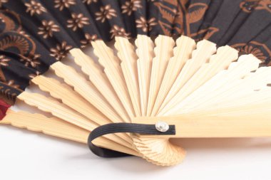 Geleneksel el katlama vantilatörünü beyaz arkaplanda izole edilmiş batik motifle kapat